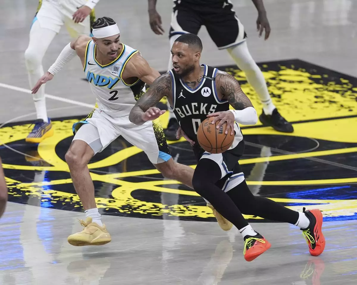 Milwaukee Bucks guard Damian Lillard (0) drives on Indiana Pacers guard Andrew Nembhard (2) during the first half of a first-round NBA basketball playoff game in Indianapolis, Tuesday, April 22, 2025. (AP Photo/Michael Conroy)