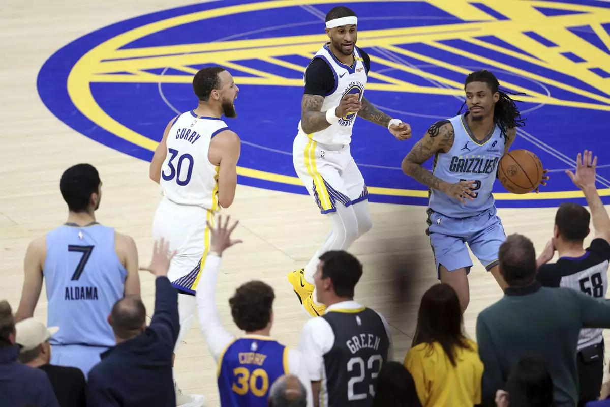 Golden State Warriors' Gary Payton II, top, and Stephen Curry (30) and Memphis Grizzlies' Ja Morant (12) react after Grizzlies turned the ball over on an out-of-bounds play in final seconds of the second half of an NBA play-in tournament basketball game in San Francisco, Tuesday, April 15, 2025. (Scott Strazzante/San Francisco Chronicle via AP)