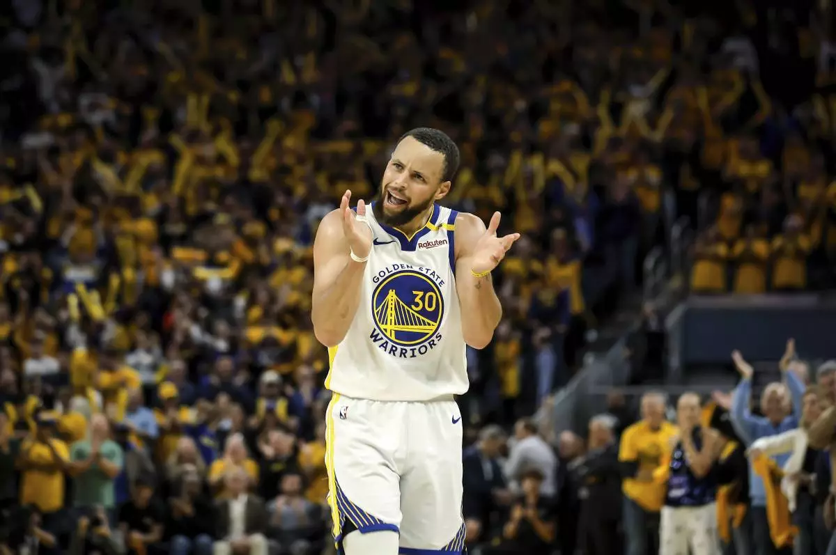 Golden State Warriors' Stephen Curry (30) claps and urges on the crowd in the second half of an NBA play-in tournament basketball game against the Memphis Grizzlies in San Francisco, on Tuesday, April 15, 2025. (Carlos Avila Gonzalez/San Francisco Chronicle via AP)