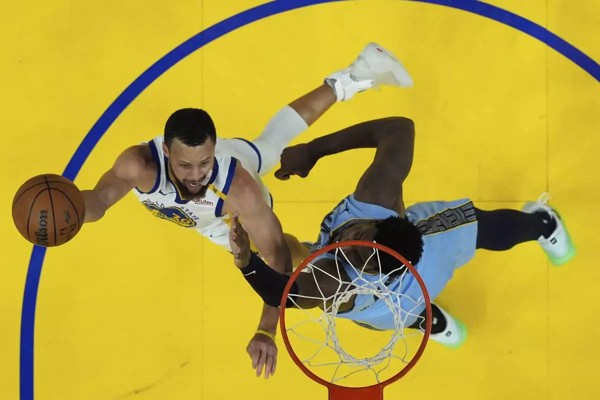 Golden State Warriors guard Stephen Curry, left, shoots against Memphis Grizzlies forward Jaren Jackson Jr. during the second half of an NBA play-in tournament basketball game in San Francisco, Tuesday, April 15, 2025. (AP Photo/Jeff Chiu)