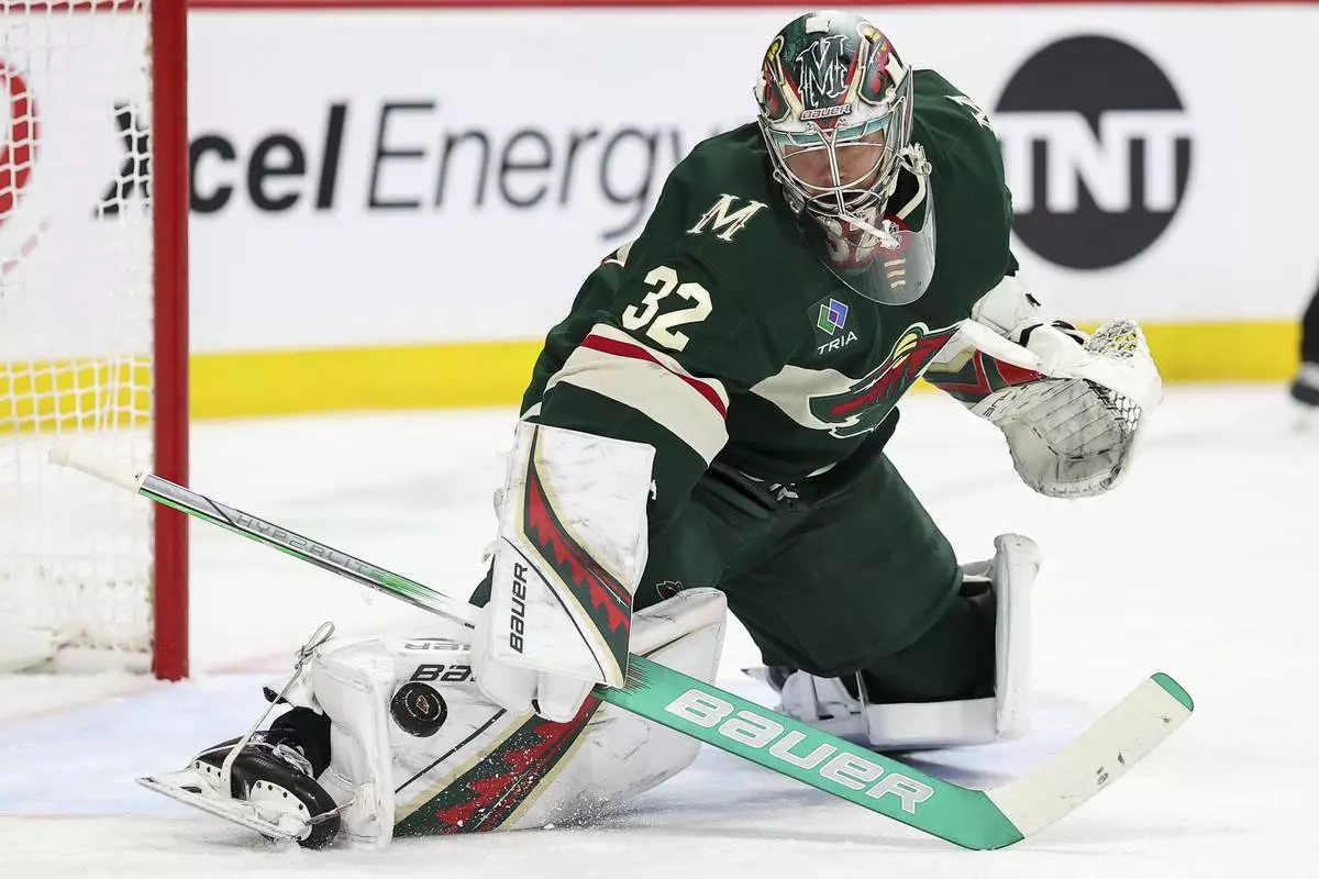 Minnesota Wild goaltender Filip Gustavsson (32) makes a save against the Dallas Stars during the second period of an NHL hockey game Sunday, April 6, 2025, in St. Paul, Minn. (AP Photo/Matt Krohn)