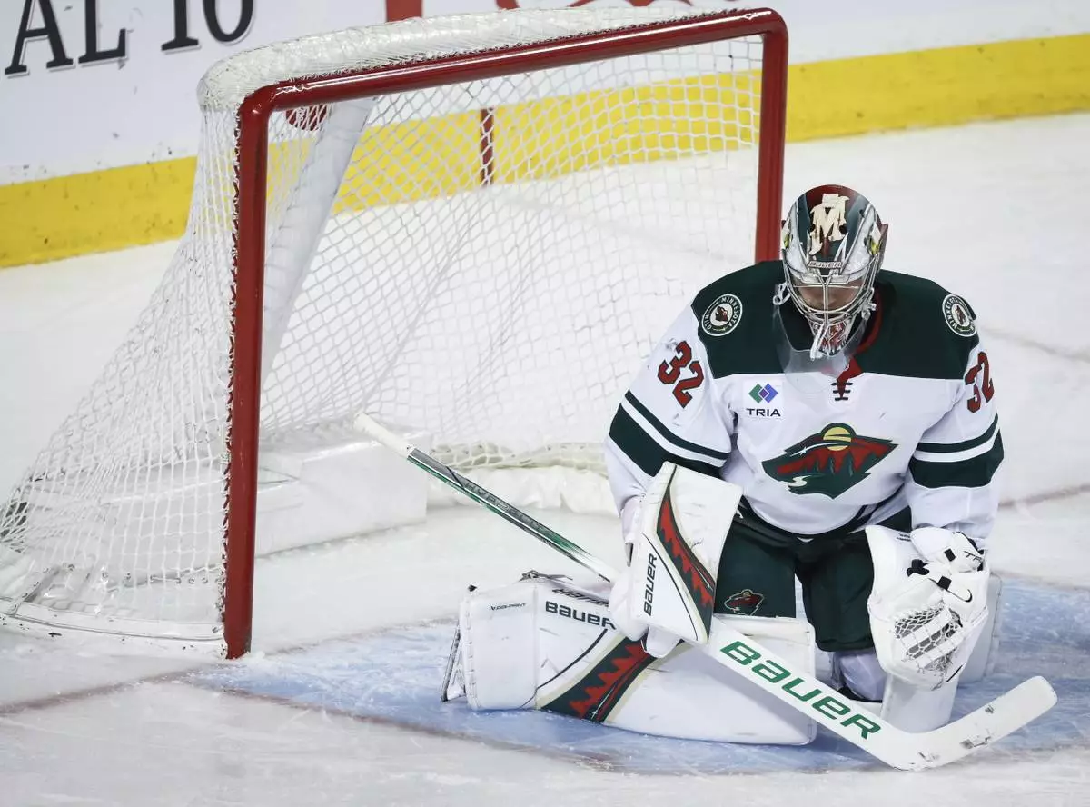Minnesota Wild goalie Filip Gustavsson (32) reacts after letting in a goal during the third period of an NHL hockey game against the Minnesota Wild in Calgary, Alberta, Friday, April 11, 2025. (Jeff McIntosh/The Canadian Press via AP)