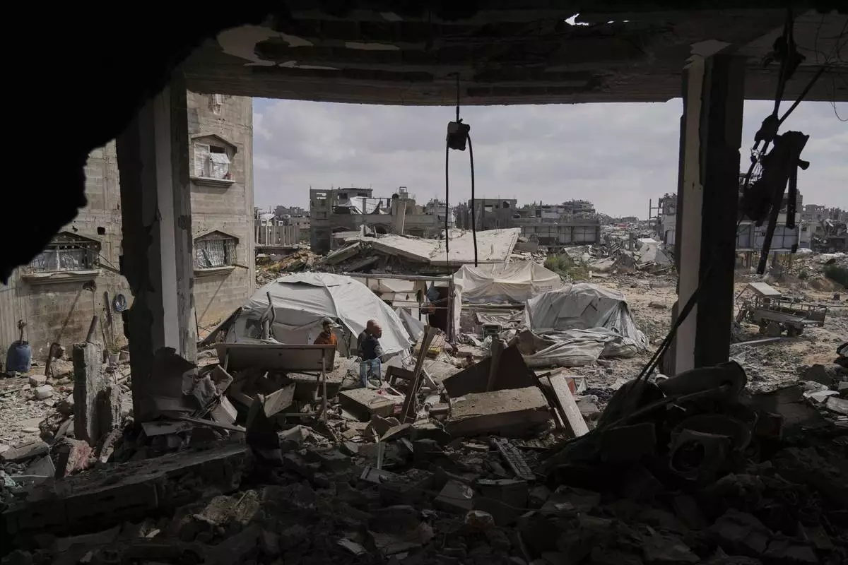 Palestinians look at the damage after an Israeli army airstrike in Beit Lahia, northern Gaza Strip, Monday, April 28, 2025. (AP Photo/Jehad Alshrafi)