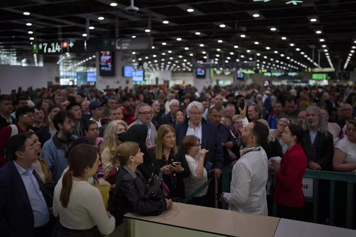 Passengers crowd the train accesses at Sants train station in Barcelona, Spain, Tuesday, April 29, 2025. (AP Photo/Emilio Morenatti)