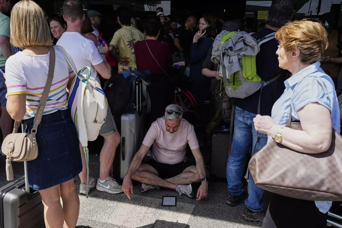 Passengers wait outside Lisbon Airport during a nationwide power outage in Lisbon, Monday, April 28, 2025. (AP Photo/Armando Franca)