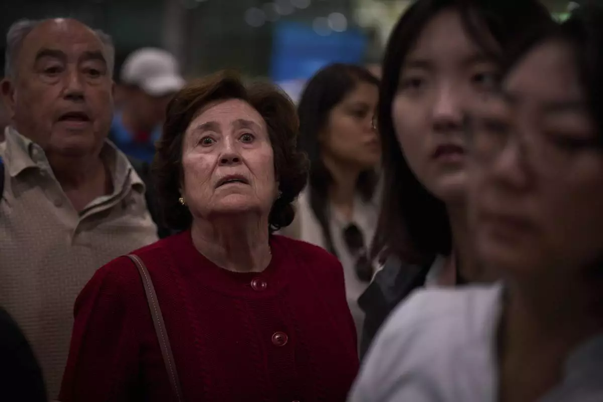 Passengers react as they wait for news of train departures, at Sants train station in Barcelona, Spain, Tuesday, April 29, 2025. (AP Photo/Emilio Morenatti)