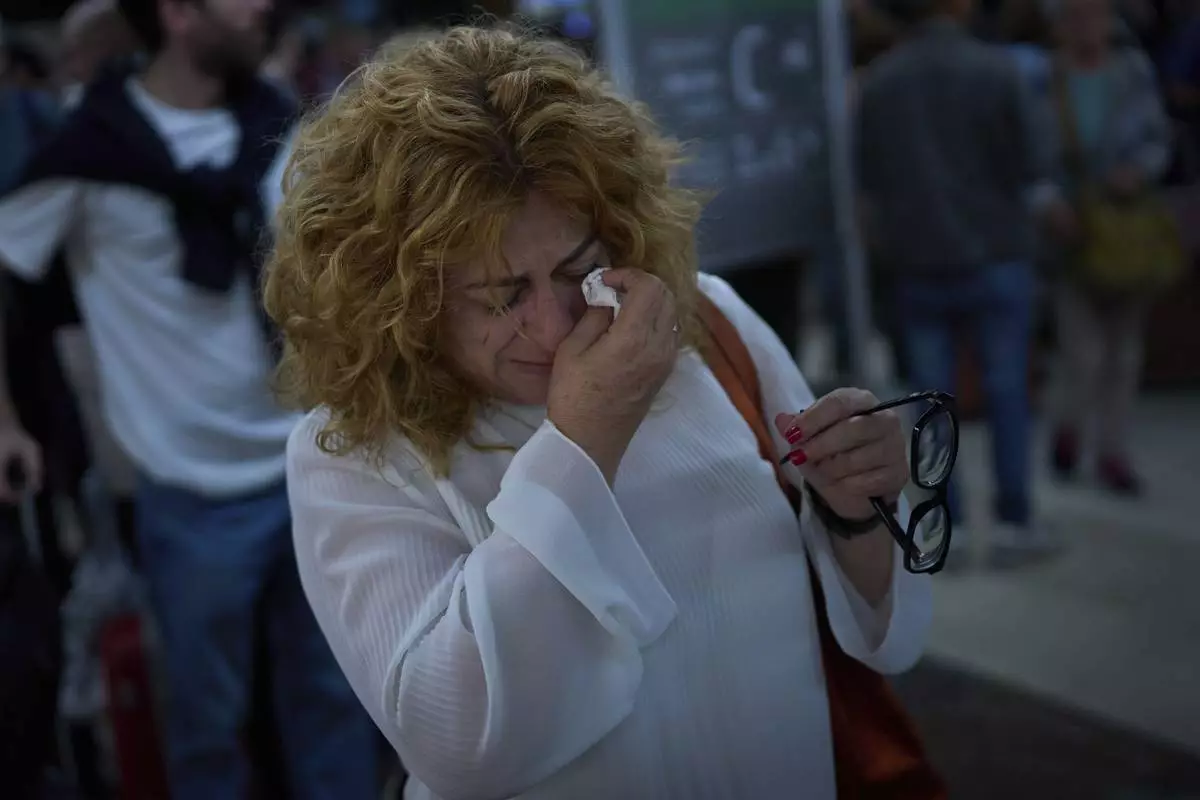 Paquita Gonzalez cries as she waits for news of train departures, after spending the whole night at the station Sants station in Barcelona, Spain, Tuesday, April 29, 2025. (AP Photo/Emilio Morenatti)