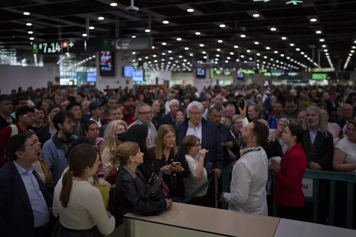 Passengers crowd the train accesses at Sants train station in Barcelona, Spain, Tuesday, April 29, 2025. (AP Photo/Emilio Morenatti)