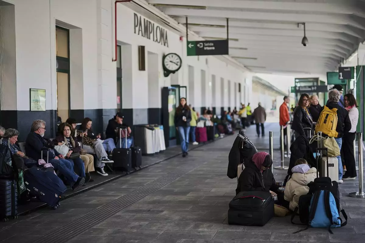 Passengers wait at a train station during a nationwide power outage in Pamplona, northern Spain, on Monday, April 28, 2025. (AP Photo/Miguel Oses)