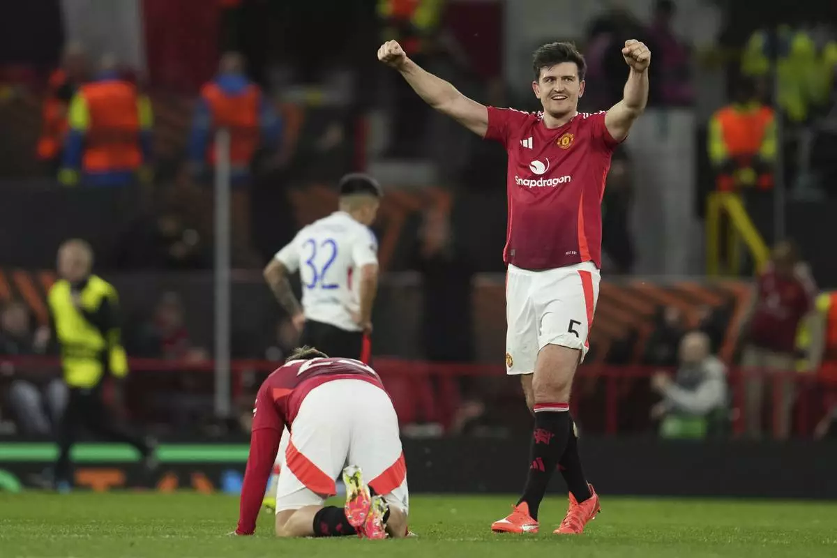 Manchester United's Harry Maguire celebrates besides Luke Shaw after the Europa League quarter final second leg soccer match between Manchester United and Olympique Lyon in Manchester, Britain, Thursday, April 17, 2025. (AP Photo/Jon Super)