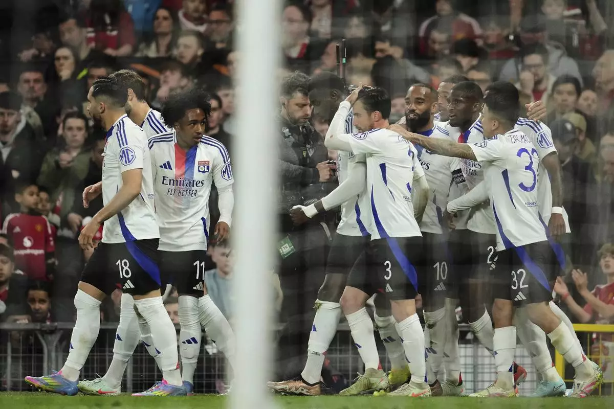Lyon's Nicolas Tagliafico, center, celebrates with team mates after scoring his side's second goal during the Europa League quarter final second leg soccer match between Manchester United and Olympique Lyon in Manchester, Britain, Thursday, April 17, 2025. (AP Photo/Jon Super)