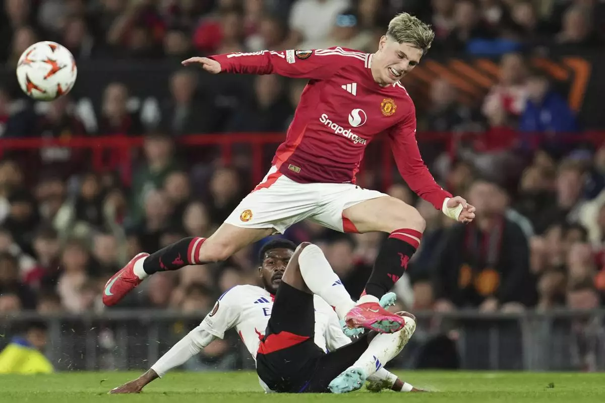 Manchester United's Alejandro Garnacho, top, and Lyon's Ainsley Maitland-Niles challenge for the ball during the Europa League quarter final second leg soccer match between Manchester United and Olympique Lyon in Manchester, Britain, Thursday, April 17, 2025. (AP Photo/Jon Super)