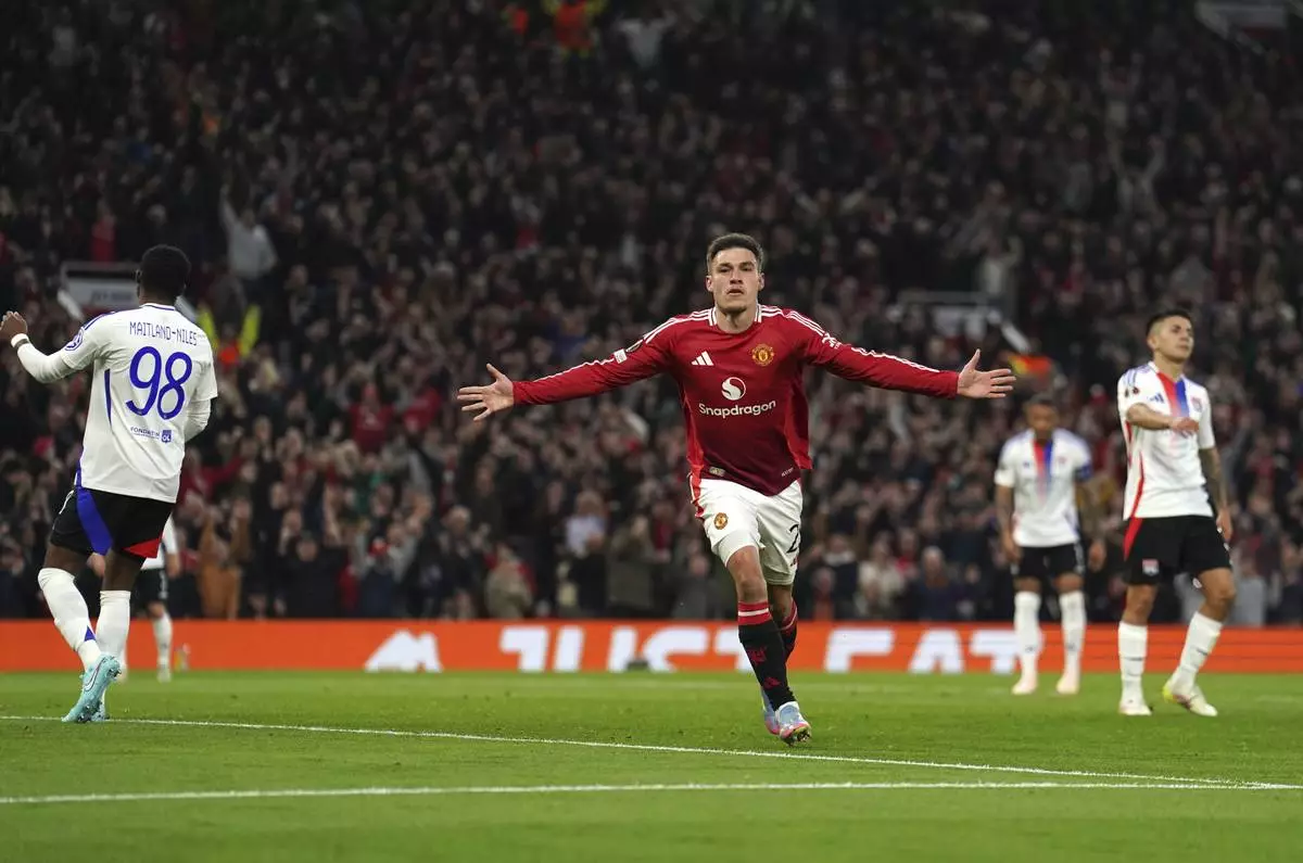Manchester United's Manuel Ugarte celebrates after scoring his side's opening goal during the Europa League quarter final second leg soccer match between Manchester United and Olympique Lyon in Manchester, England, Thursday, April 17, 2025. (Martin Rickett/PA via AP)