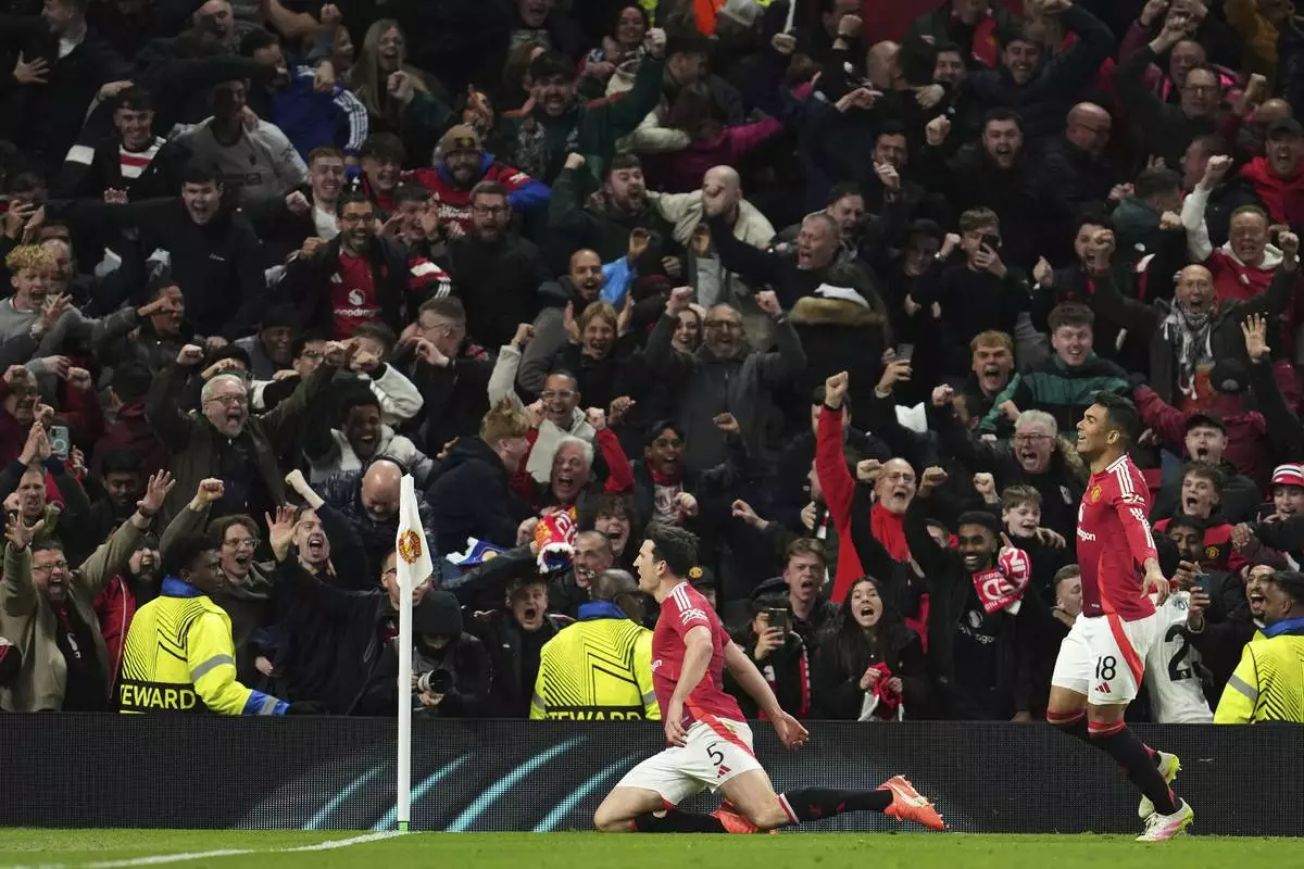 Manchester United's Harry Maguire, left, celebrates with team mates after his side's fifth goal during the Europa League quarter final second leg soccer match between Manchester United and Olympique Lyon in Manchester, Britain, Thursday, April 17, 2025. (AP Photo/Jon Super)