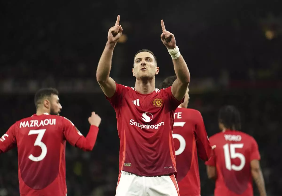 Manchester United's Diogo Dalot celebrates scoring during the Europa League quarterfinal second leg soccer match between Manchester United and Olympique Lyon in Manchester, England, Thursday, April 17, 2025. (Martin Rickett/PA via AP)
