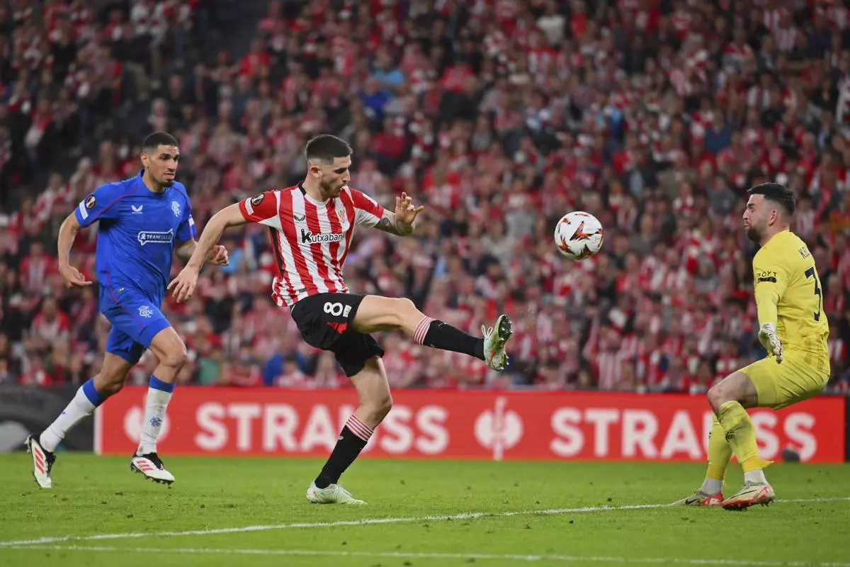 Athletic Bilbao's Oihan Sancet, centre, tries to score past Rangers' goalkeeper Liam Kelly during the Europa League quarter final second leg soccer match between Athletic Bilbao and Glasgow Rangers in Bilbao, Spain, Thursday, April 17, 2025. (AP Photo/Miguel Oses)
