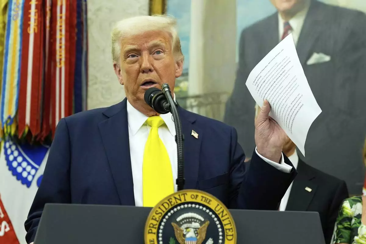 President Donald Trump holds a document with notes about Kilmar Abrego Garcia as he speaks with reporters during a swearing in ceremony for Dr. Mehmet Oz to be Administrator of the Centers for Medicare and Medicaid Services, in the Oval Office of the White House, Friday, April 18, 2025, in Washington. (AP Photo/Alex Brandon)