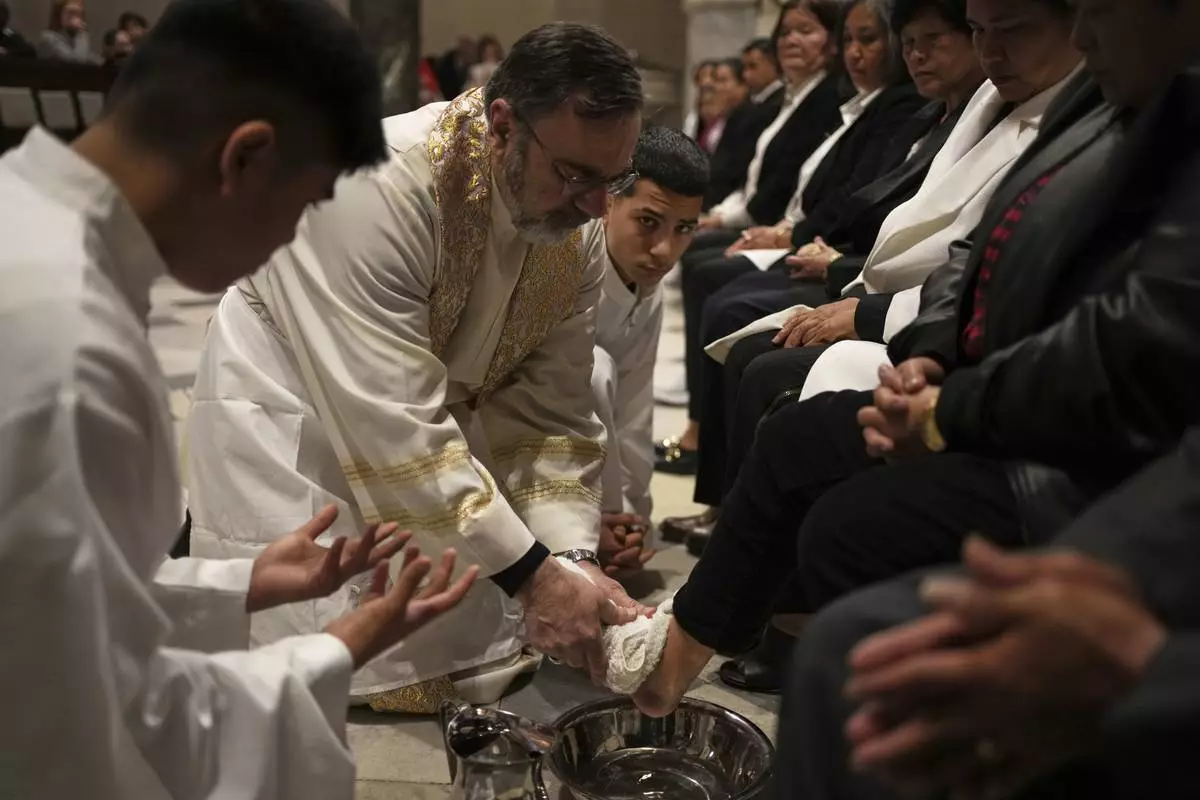 Theodoros Kondidis S.J., Catholic Archbishop of Athens, washes the feet of a woman during the Mass of Last Supper at the Catholic Cathedral Basilica of St Dionysius the Areopagite in Athens, Greece, Holy Thursday, April 17, 2025. (AP Photo/Thanassis Stavrakis)