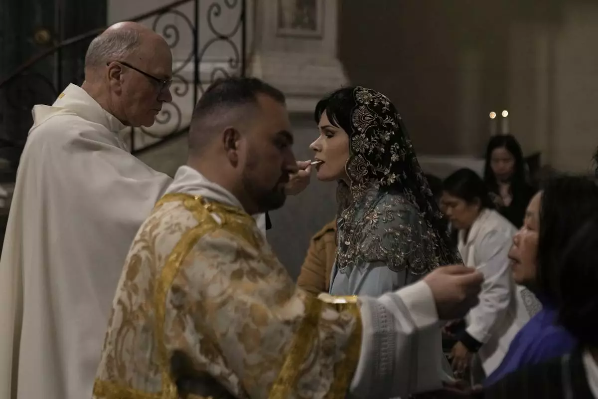 Greek Catholic believers and foreigners who live in Greece take communion during the Mass of Last Supper at the Catholic Cathedral Basilica of St Dionysius the Areopagite in Athens, Greece, Holy Thursday, April 17, 2025. (AP Photo/Thanassis Stavrakis)