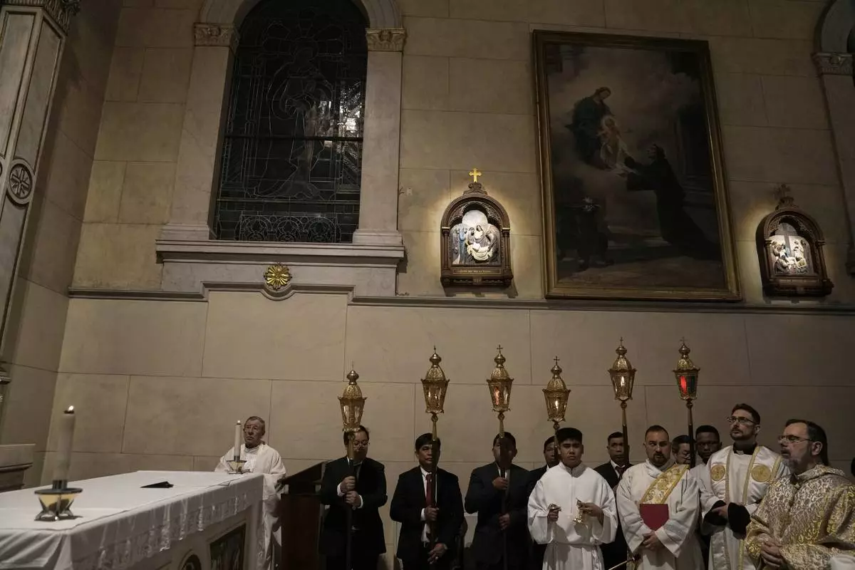 Theodoros Kondidis S.J., Catholic Archbishop of Athens, right, prays during the Mass of Last Supper at the Catholic Cathedral Basilica of St Dionysius the Areopagite in Athens, Greece, Holy Thursday, April 17, 2025. (AP Photo/Thanassis Stavrakis)