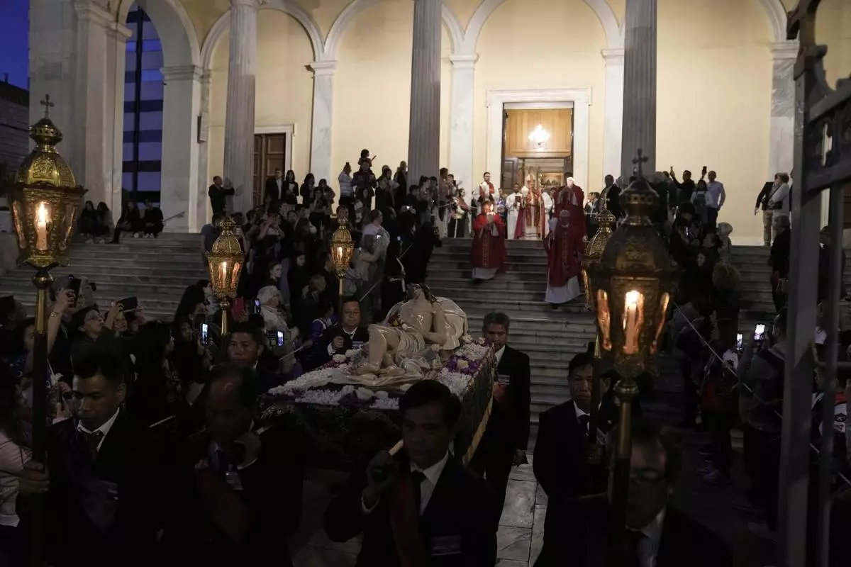 Greek Catholic believers and foreigners who live in Greece attend the Epitaph Procession at the Catholic Cathedral Basilica of St Dionysius the Areopagite in Athens, Greece, Good Friday, April 18, 2025. (AP Photo/Thanassis Stavrakis)