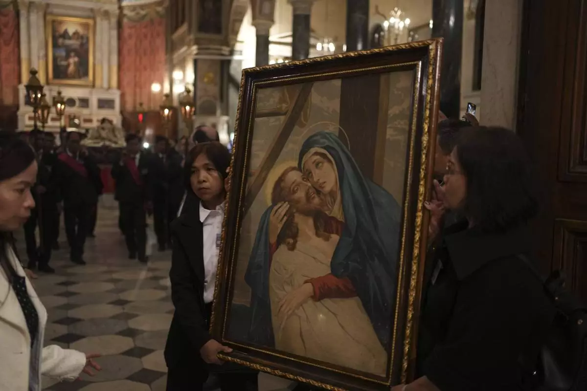 Greek Catholic believers and foreigners who live in Greece attend the Epitaph Procession at the Catholic Cathedral Basilica of St Dionysius the Areopagite in Athens, Greece, Good Friday, April 18, 2025. (AP Photo/Thanassis Stavrakis)