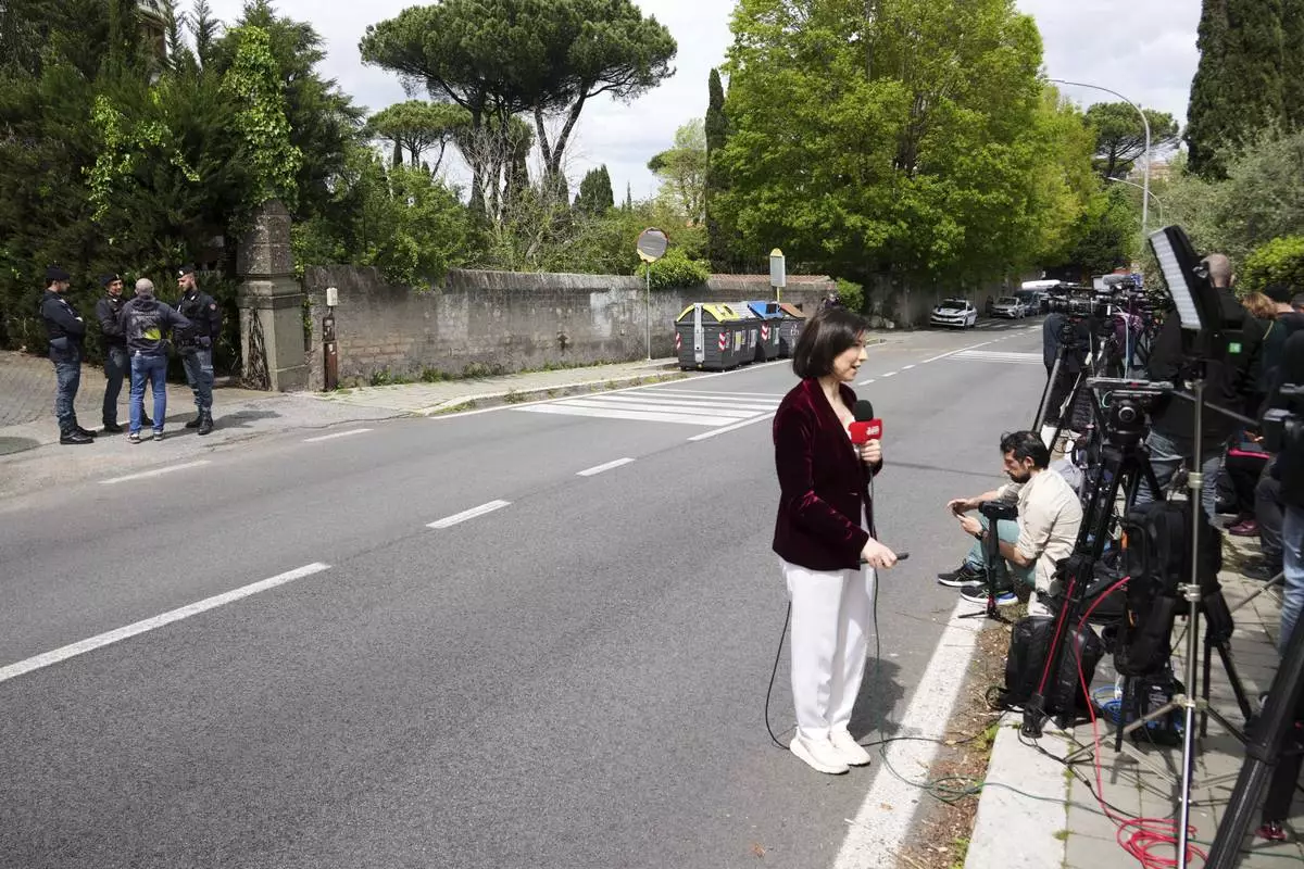 Police and reporters stand outside the Omani Embassy in Rome during a closed-door meeting between U.S. and Iranian delegations to discuss Tehran's rapidly advancing nuclear program, Saturday, April 19, 2025. (AP Photo/Andrew Medichini)