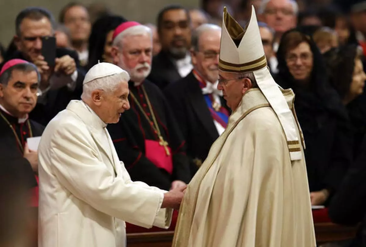 FILE - Pope Emeritus Benedict XVI, left, greets Pope Francis in St. Peter's Basilica at the Vatican, Saturday, Feb. 14, 2015. (AP Photo/Andrew Medichini, file)