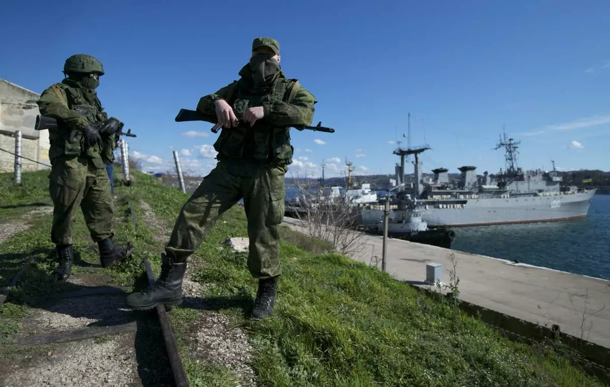 FILE - Russian soldiers guard a pier where two Ukrainian naval vessels are moored, in Sevastopol, on the Crimean Peninsula, March 5, 2014. (AP Photo, File)