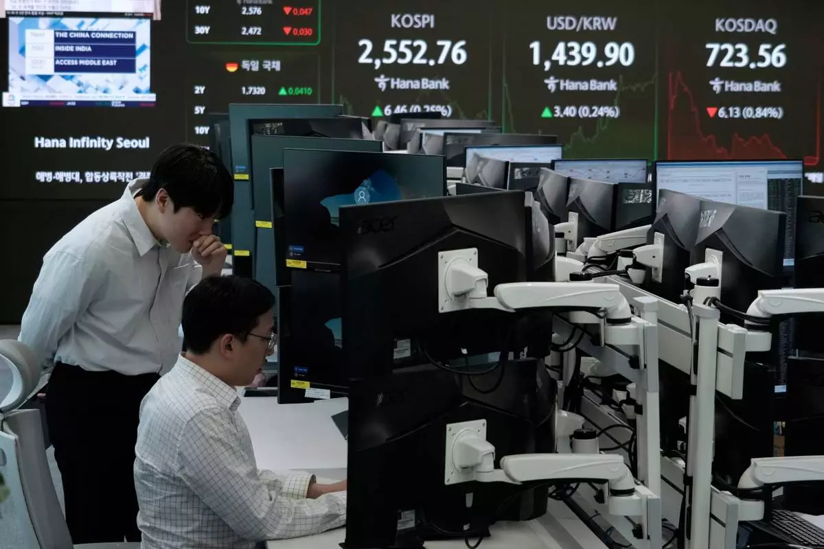 Currency traders work near a screen showing the Korea Composite Stock Price Index (KOSPI), top third from right, and the foreign exchange rate between U.S. dollar and South Korean won, top second from right, at the foreign exchange dealing room of the KEB Hana Bank headquarters in Seoul, South Korea, Monday, April 28, 2025. (AP Photo/Ahn Young-joon)