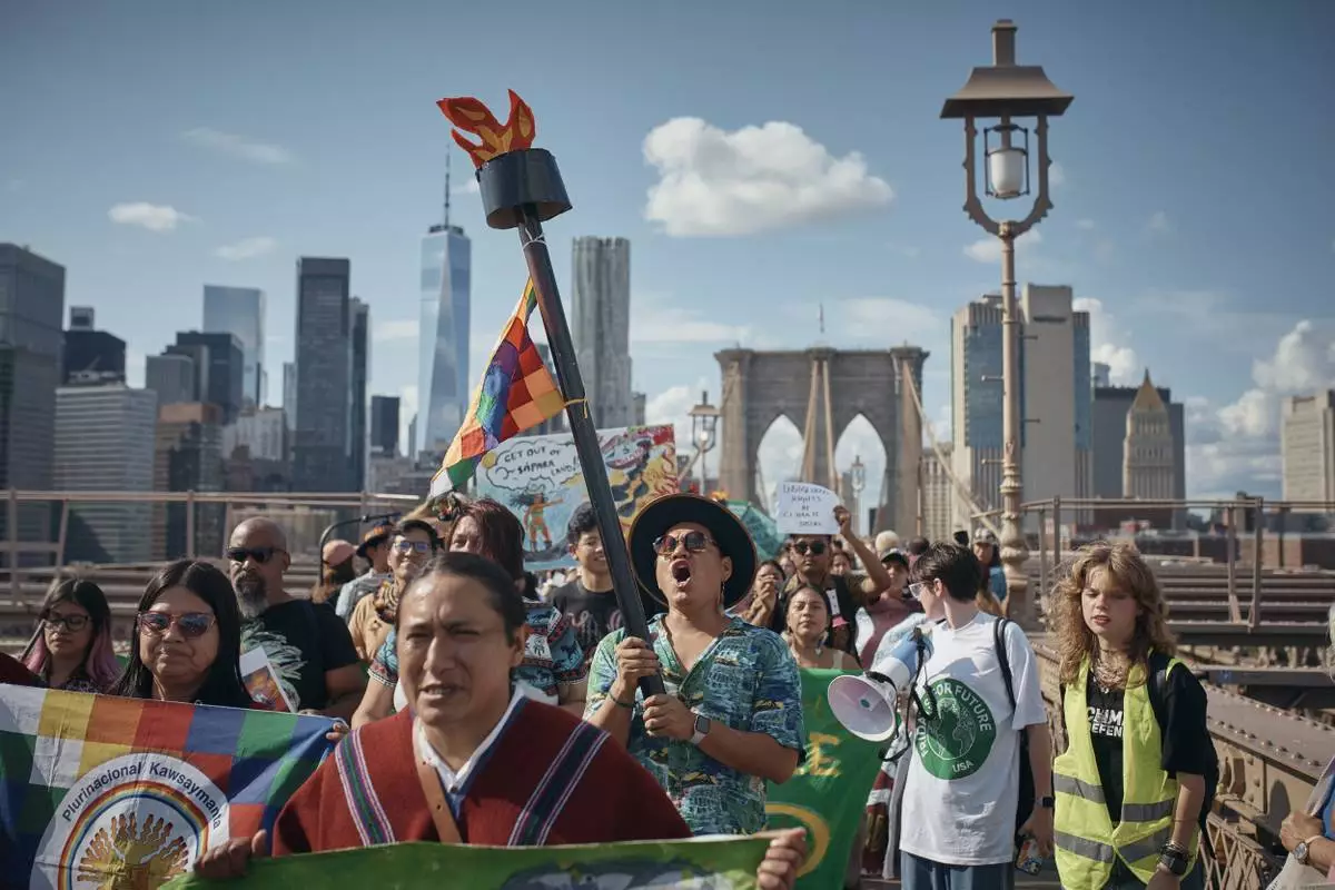 FILE - Protesters shout slogans as they cross the Brooklyn Bridge during a Youth Climate Strike march to demand an end to the era of fossil fuels, Friday, Sept. 20, 2024, in New York. (AP Photo/Andres Kudacki, File)