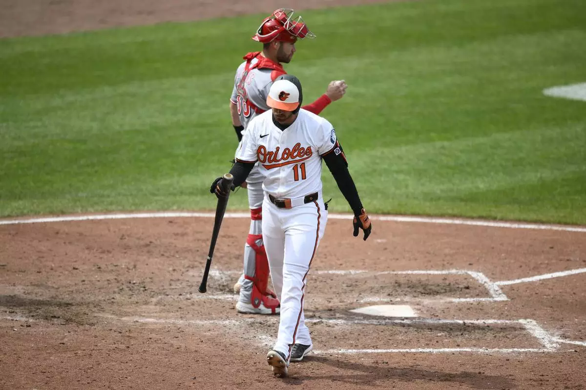 Baltimore Orioles' Jordan Westburg, front, walks back to the dugout past Cincinnati Reds catcher Austin Wynns, back, after he struck out during the fourth inning of a baseball game, Sunday, April 20, 2025, in Baltimore. (AP Photo/Nick Wass)