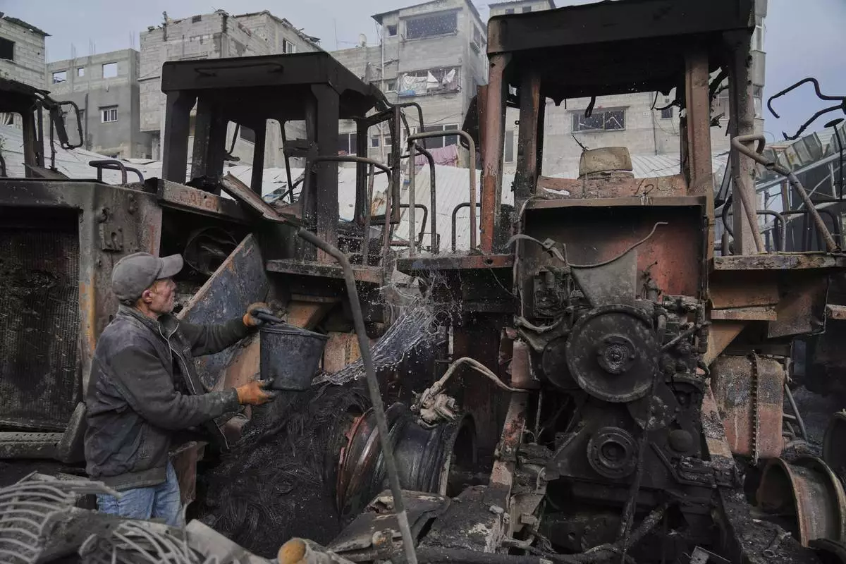 A Palestinian man extinguishes the fire from bulldozers after they were hit by an Israeli army airstrike in Jabaliya, northern Gaza Strip, on Tuesday, April 22, 2025. (AP Photo/Jehad Alshrafi)
