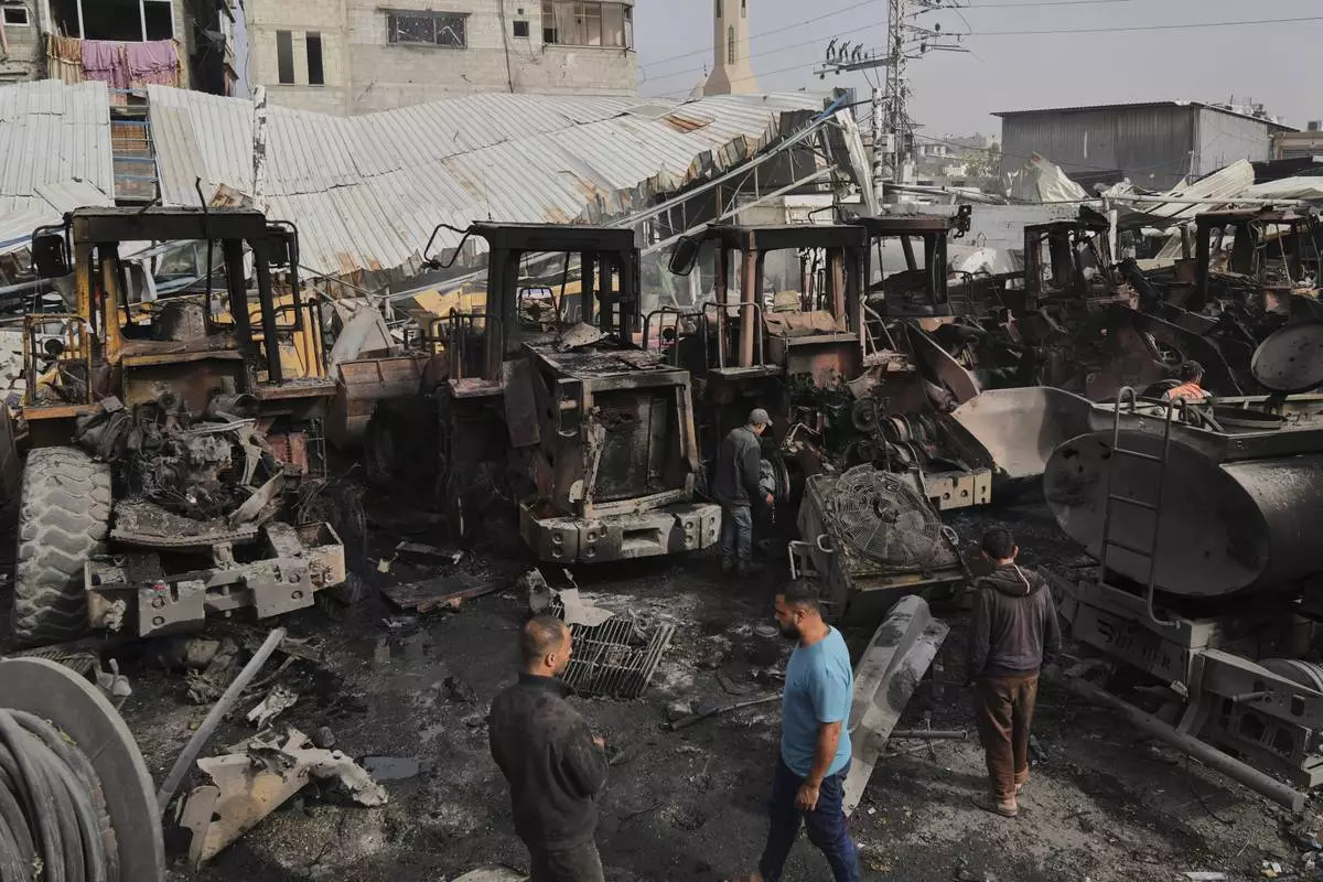 Palestinians examine the remains of bulldozers hit by an Israeli army airstrike in Jabaliya, northern Gaza Strip, on Tuesday, April 22, 2025. (AP Photo/Jehad Alshrafi)