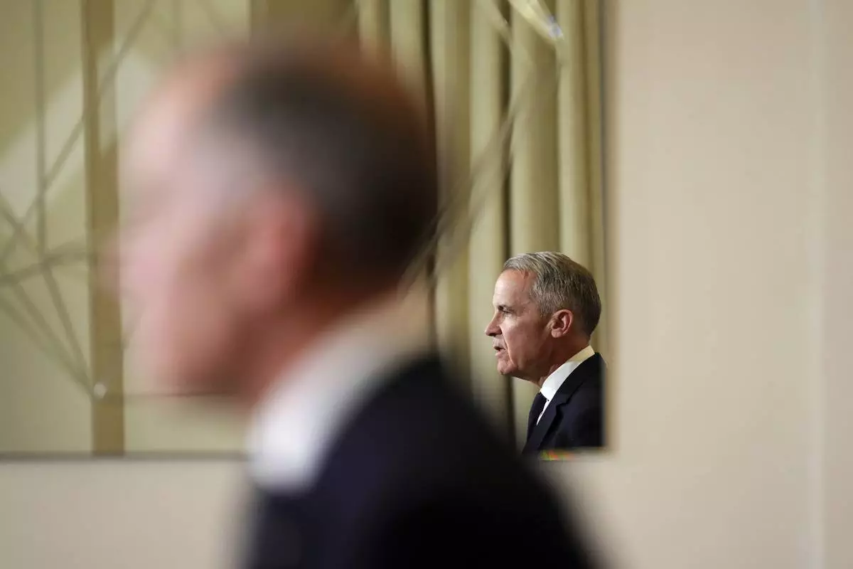 FILE - Canada's Prime Minister Mark Carney, reflected in a mirror, speaks to media during a press conference at Canada House in London on March 17, 2025. (Sean Kilpatrick/The Canadian Press via AP, File)