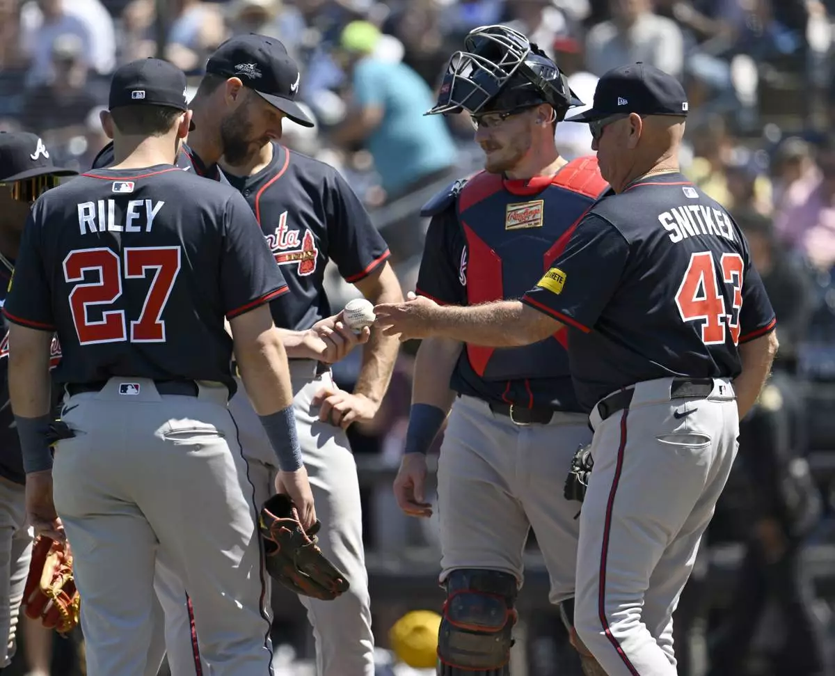 Atlanta Braves manager Brian Snitker (43) pulls starting pitcher Chris Sale from the game during the sixth inning of a baseball game against the Tampa Bay Rays, Sunday, April 13, 2025, in Tampa, Fla. (AP Photo/Jason Behnken)