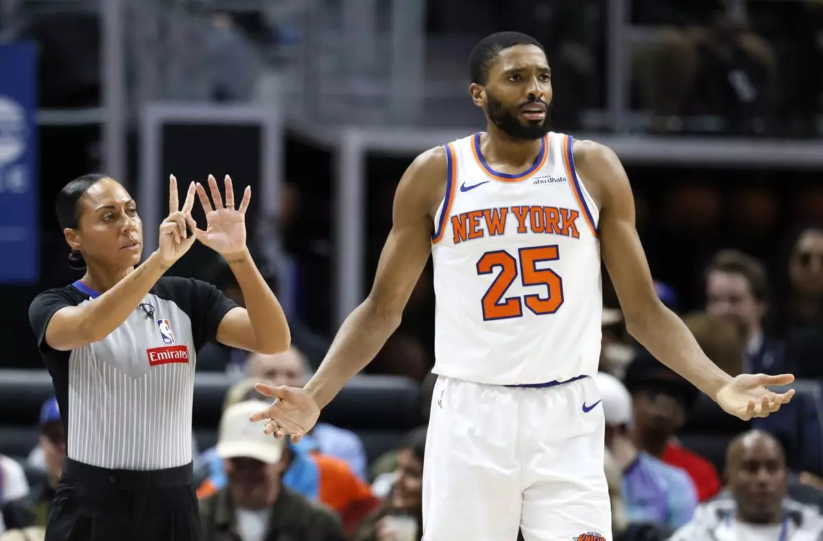 New York Knicks forward Mikal Bridges (25) reacts after being called for a foul by referee Sha'Rae Mitchell, left, during the first half of an NBA basketball game against the Detroit Pistons, Thursday, April 10, 2025, in Detroit. (AP Photo/Duane Burleson)