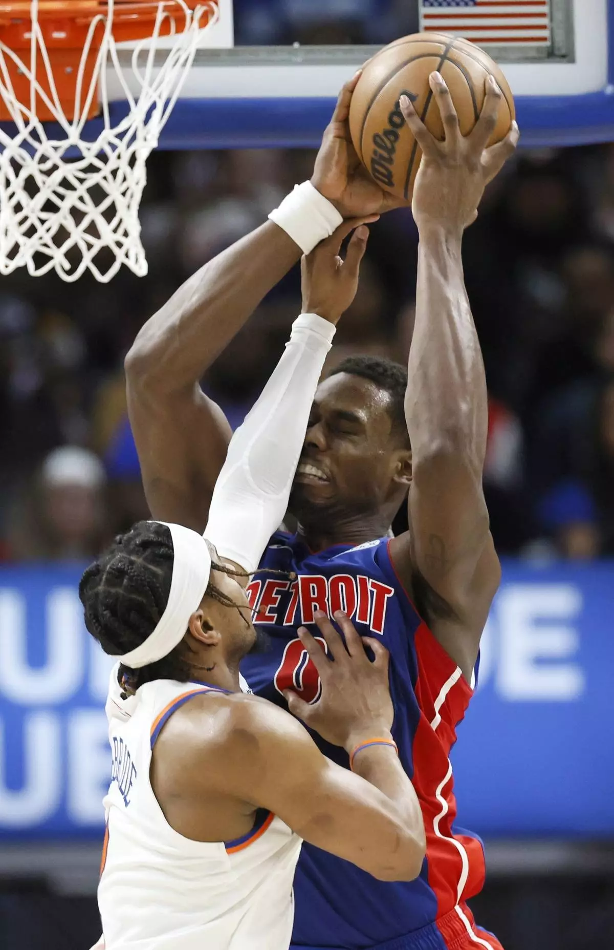 New York Knicks guard Miles McBride, left, defends against a shotort by Detroit Pistons center Jalen Duren, right, during the first half of an NBA basketball game Thursday, April 10, 2025, in Detroit. (AP Photo/Duane Burleson)
