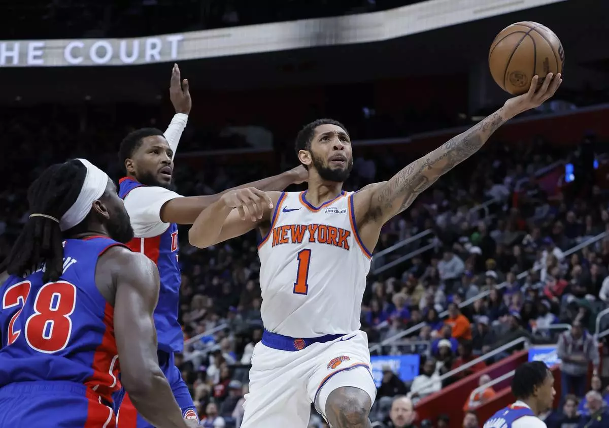 New York Knicks forward Precious Achiuwa (5) goes to the basket past Detroit Pistons center Isaiah Stewart (28) and guard Malik Beasley, center, during the first half of an NBA basketball game Thursday, April 10, 2025, in Detroit. (AP Photo/Duane Burleson)