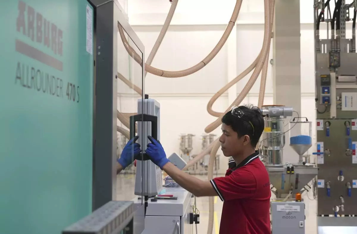 A worker operates a moulding machine at Lego factory in Binh Duong, Vietnam Wednesday, April 2, 2025. (AP Photo/Hau Dinh)