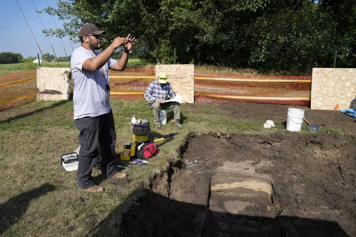 FILE - Omaha Tribe member Mark Parker, of Macy, Neb., takes a photo as workers dig for the suspected remains of children who once attended the Genoa Indian Industrial School, July 11, 2023, in Genoa, Neb. (AP Photo/Charlie Neibergall, File)