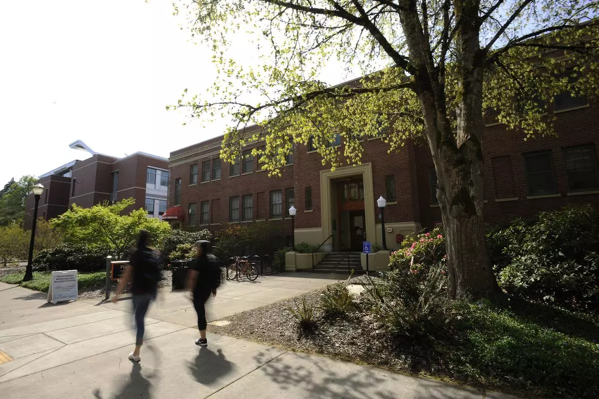 FILE - Oregon State University students walk past the Student Health Services building in Corvallis, Ore., in April 2016. (Anibal Ortiz/The Corvallis Gazette-Times via AP)