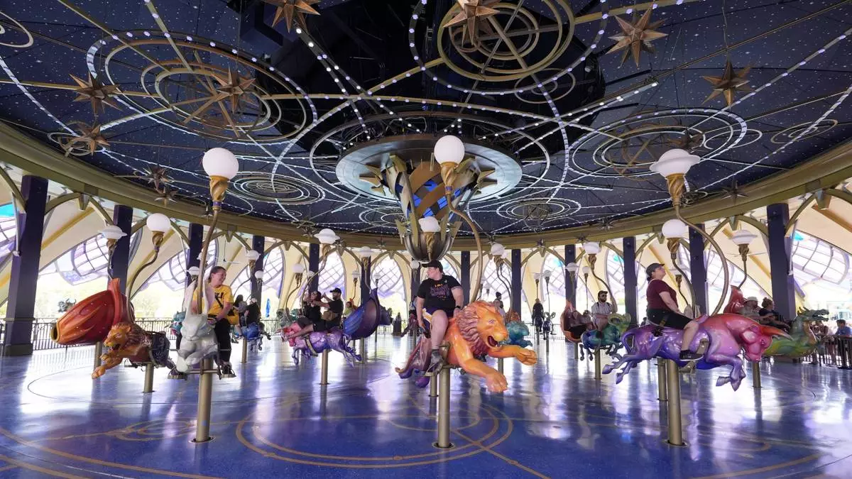 Guests ride the Constellation Carousel in Celestial Park in Epic Universe at Universal Resort Orlando Thursday, April 10, 2025, in Orlando, Fla. (AP Photo/John Raoux)