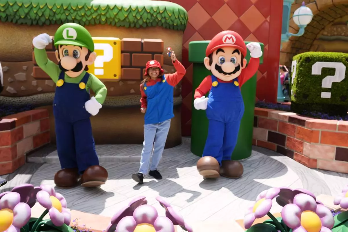 A guest interacts with characters in Super Nintendo World at Epic Universe at Universal Resort Orlando Thursday, April 10, 2025, in Orlando, Fla. (AP Photo/John Raoux)