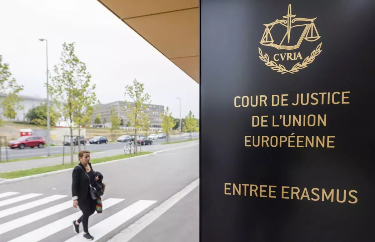 FILE - In this file photo taken on Oct. 5, 2015 a woman walks by the entrance to the European Court of Justice in Luxembourg. (Geert Vanden Wijngaert, File)