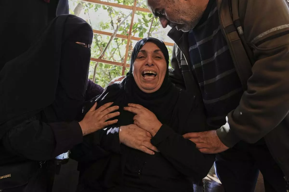 A Relative of 10 members of the Abu Al-Rous family, killed when an Israeli airstrike struck their displacement tent overnight, reacts during their funeral in Khan Younis, southern Gaza Strip, Thursday, April 17, 2025. (AP Photo/Abdel Kareem Hana)