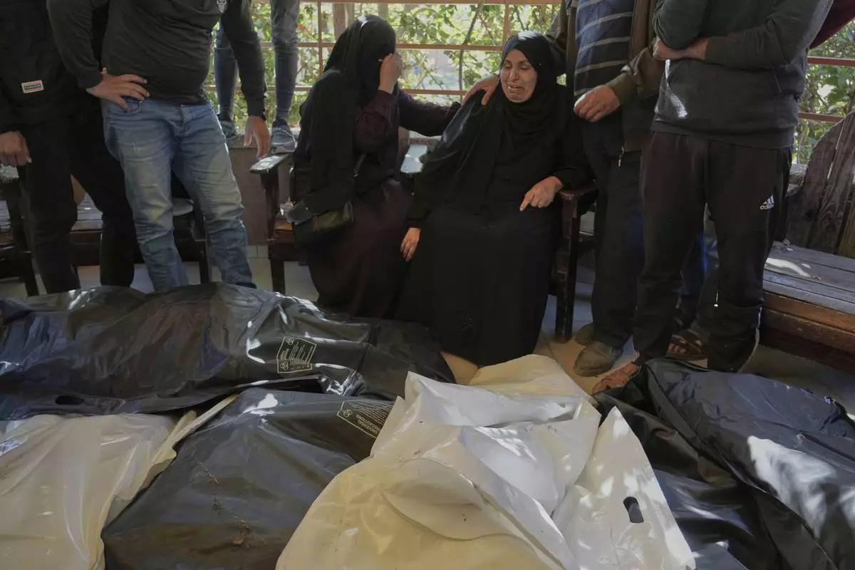Relatives Mourn over the bodies of 10 members of the Abu Al-Rous family, killed when an Israeli airstrike struck their displacement tent overnight, during their funeral in Khan Younis, southern Gaza Strip, Thursday, April 17, 2025. (AP Photo/Abdel Kareem Hana)
