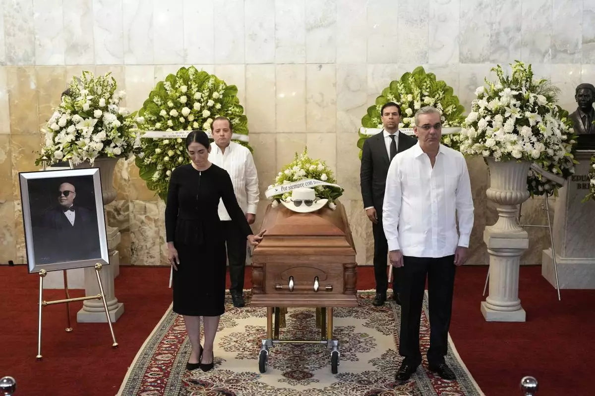 Dominican Republic President Luis Abinader, front right ands his wife Raquel Arbaje Soni, front left, attend the wake of Dominican singer Rubby Perez who died in the roof collapse at the Jet Set nightclub during his merengue concert, at the Eduardo Brito National Theater in Santo Domingo, Dominican Republic, Thursday, April 10, 2025. (AP Photo/Matias Delacroix)