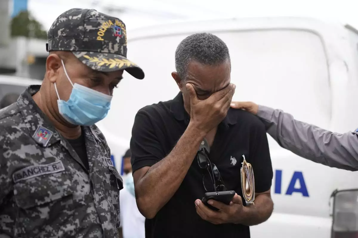 Carlos Severino, whose three children died in the Jet Set nightclub when a roof collapsed during a merengue concert, is consoled as he waits to receive the remains of his children, outside the morgue of the National Institute of Forensic Pathology in Santo Domingo, Dominican Republic, Friday, April 11, 2025. (AP Photo/Matias Delacroix)