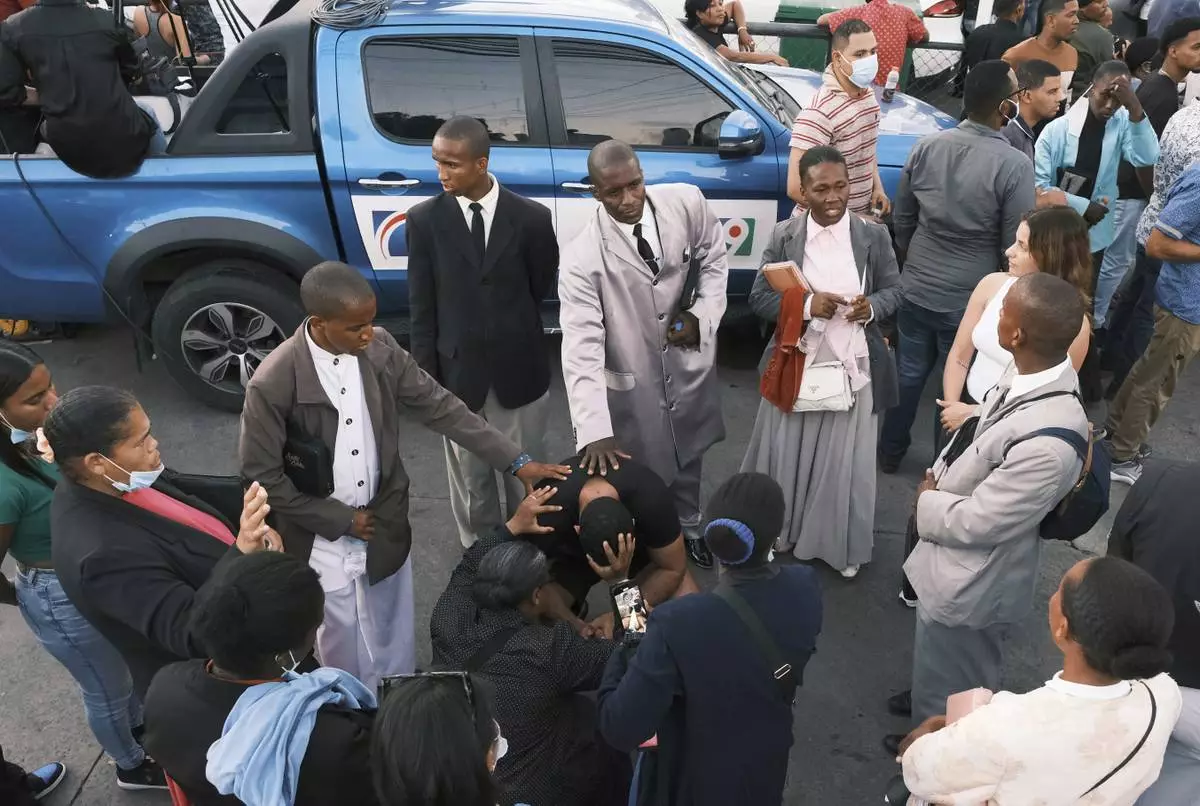 People pray for their missing relatives outside Jet Set nightclub after its roof collapsed during a merengue concert in Santo Domingo, Dominican Republic, Wednesday, April 9, 2025. (AP Photo/Ricardo Hernandez)